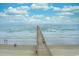 Long pier stretching out into the ocean under a blue sky with clouds, showing people enjoying the beach at 6000 N Ocean Blvd. # 119, North Myrtle Beach, SC 29582