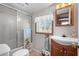 Bright bathroom featuring a shower with glass doors, and a vanity with a decorative mirror and towel racks at 6001-5742 S Kings Hwy., Myrtle Beach, SC 29575