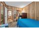 Cozy bedroom featuring wood paneled walls, a blue bedspread, and warm lighting to create a relaxing ambiance at 6001-5742 S Kings Hwy., Myrtle Beach, SC 29575