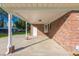 Spacious brick carport area with a white door, offering ample covered parking and access to the home at 64 Highway 521, Andrews, SC 29510