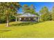 Charming home with a large yard features a covered patio with ceiling fans and inviting seating areas at 64 Highway 521, Andrews, SC 29510