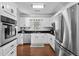 Well-lit kitchen with white cabinets, stainless steel appliances, and hardwood floors at 64 Highway 521, Andrews, SC 29510