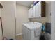 A functional laundry room features a washer and dryer set, cabinets, and cleaning supplies at 64 Highway 521, Andrews, SC 29510