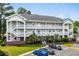 Exterior of multi-story condominium featuring white balconies, brick accents, and well-maintained landscaping at 682 Riverwalk Dr. # 102, Myrtle Beach, SC 29579
