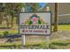 Community sign for Riverwalk on the Waterway with a floral design, set among colorful flowers and landscaping at 682 Riverwalk Dr. # 102, Myrtle Beach, SC 29579