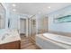Primary bathroom featuring dual sinks, a glass shower and a soaking tub to unwind at 703 S Waccamaw Dr., Garden City Beach, SC 29576
