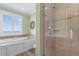 Well-lit bathroom features a glass enclosed shower and separate soaking tub for ultimate relaxation at 703 S Waccamaw Dr., Garden City Beach, SC 29576