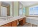 Bathroom showcasing double sinks, soaking tub, and coastal inspired decor, creating a relaxing atmosphere at 703 S Waccamaw Dr., Garden City Beach, SC 29576