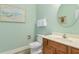 Cozy bathroom with a light vanity, white toilet, and decorative beach themed art at 703 S Waccamaw Dr., Garden City Beach, SC 29576