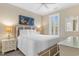 Cozy bedroom features a plush bed, complemented by coastal decor and a ceiling fan at 703 S Waccamaw Dr., Garden City Beach, SC 29576