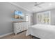 Light-filled bedroom with a beach view TV, complemented by white furniture and serene decor at 703 S Waccamaw Dr., Garden City Beach, SC 29576