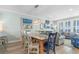 Open-concept dining area featuring a glass top table, that flows into the living area with ample light at 703 S Waccamaw Dr., Garden City Beach, SC 29576