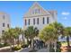 Beautiful coastal home on stilts with palm trees and beach access, perfect for relaxed seaside living at 703 S Waccamaw Dr., Garden City Beach, SC 29576