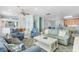 Coastal living room boasts blue furniture, ceiling fan, and access to the dining area at 703 S Waccamaw Dr., Garden City Beach, SC 29576