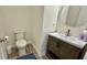 Bathroom featuring a modern vanity, toilet, and round mirror; wood-look flooring at 7040 Belancino Blvd., Myrtle Beach, SC 29572