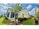 Exterior home view featuring a well-maintained lawn, plantings, and a screened porch at 7040 Belancino Blvd., Myrtle Beach, SC 29572