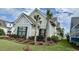 Charming home featuring attractive landscaping with colorful flowering plants and small palm trees at 7040 Belancino Blvd., Myrtle Beach, SC 29572