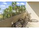 View of a balcony featuring two chairs and a small table, with a view of palm trees and a beach at 7100 N Ocean Blvd. # 204, Myrtle Beach, SC 29572