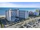 Aerial view of a modern high-rise beachfront resort with multiple floors and many rooms at 7100 N Ocean Blvd. # 204, Myrtle Beach, SC 29572