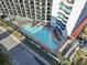 Aerial view of a large outdoor pool area, complete with lounge chairs and palm trees at 7100 N Ocean Blvd. # 204, Myrtle Beach, SC 29572
