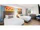 Bright bedroom featuring two beds, beach themed art, and wood floors at 7100 N Ocean Blvd. N # 321, Myrtle Beach, SC 29572