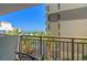 Balcony view of ocean, pool, parking area, and adjacent hotel from a resort balcony with chairs at 7200 N Ocean Blvd. # 360, Myrtle Beach, SC 29572
