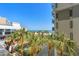 Exterior view of resort, ocean, and pool area framed by lush palm trees on a sunny day at 7200 N Ocean Blvd. # 360, Myrtle Beach, SC 29572