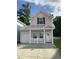 Charming pink two-story home with a front porch, white railings, and a well-maintained lawn at 739 Shell Creek Circle # 739, North Myrtle Beach, SC 29582