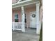Inviting front porch features white columns, a wreath on the door, and seating area at 739 Shell Creek Circle # 739, North Myrtle Beach, SC 29582