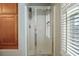 Bathroom featuring a glass-enclosed shower with cabinets, shower caddy, and window shutters at 750 Howard Ave. # C, Myrtle Beach, SC 29577