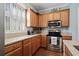Well-lit kitchen features wood cabinets, granite countertops, stainless steel appliances, and plantation shutters at 750 Howard Ave. # C, Myrtle Beach, SC 29577