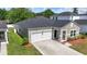 Rear view of home showing neutral siding, well maintained lawn, one car garage, and nicely landscaped entry at 751 Dusty Pine Way, Myrtle Beach, SC 29588