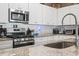 Close up of spacious kitchen featuring granite countertops, stainless steel appliances, and white cabinets at 751 Dusty Pine Way, Myrtle Beach, SC 29588