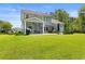 Large backyard featuring a screened porch, patio with seating, fire pit, and lush green lawn at 818 Mourning Dove Dr., Myrtle Beach, SC 29577