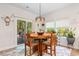 Cozy dining area with a round wooden table, four chairs, and natural light streaming in from the windows at 818 Mourning Dove Dr., Myrtle Beach, SC 29577