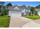 Charming two-story home with light blue siding, a two-car garage, and a well-maintained front yard at 818 Mourning Dove Dr., Myrtle Beach, SC 29577