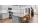 Modern white kitchen with granite countertops, stainless steel appliances, and a breakfast bar seating three at 818 Mourning Dove Dr., Myrtle Beach, SC 29577
