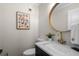 Chic powder room boasts a marble countertop, round mirror and modern fixtures at 824 N Waccamaw Dr. # 204, Murrells Inlet, SC 29576
