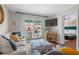 Bright living room with a sofa, patterned ottoman, and balcony access at 824 N Waccamaw Dr. # 204, Murrells Inlet, SC 29576