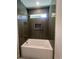 Modern bathroom with white soaking tub and beautiful herringbone tile shower surround at 5009 Middleton Dr., Myrtle Beach, SC 29579
