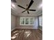 Bright bedroom featuring tray ceiling, large windows, hardwood floors and modern ceiling fan at 5009 Middleton Dr., Myrtle Beach, SC 29579