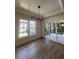 Bright dining room with hardwood floors, contemporary chandelier, large windows, and sliding door to deck at 5009 Middleton Dr., Myrtle Beach, SC 29579