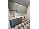 Well-lit laundry room with gray cabinets, sleek countertop, modern sink and black and white checkered floor at 5009 Middleton Dr., Myrtle Beach, SC 29579