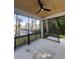 A covered screened porch with black railing and fan overlooks a yard with a pool at 5009 Middleton Dr., Myrtle Beach, SC 29579