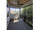 An airy screened porch features black railings, a ceiling fan, and wooded views at 5009 Middleton Dr., Myrtle Beach, SC 29579