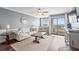 Living room features a sofa, decorative pillows, accent chair, balcony access with an ocean view at 917 S Ocean Blvd. # 103, Surfside Beach, SC 29575