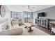 Living room featuring a white sofa, decorative pillows, a ceiling fan, and access to the balcony with an ocean view at 917 S Ocean Blvd. # 103, Surfside Beach, SC 29575