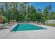 Community swimming pool surrounded by lounge chairs, tables, and mature trees at 950 Henry James Dr., Myrtle Beach, SC 29579
