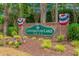 Community sign for Covington Lake East surrounded by American flags and greenery at 950 Henry James Dr., Myrtle Beach, SC 29579