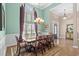 Bright dining room with high ceilings, large windows, an elegant chandelier and seating for eight at 950 Henry James Dr., Myrtle Beach, SC 29579